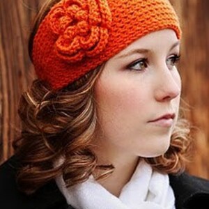 May include: A bright orange crocheted headband with a matching flower accent. The headband is made of soft yarn and is perfect for keeping your ears warm in the winter.