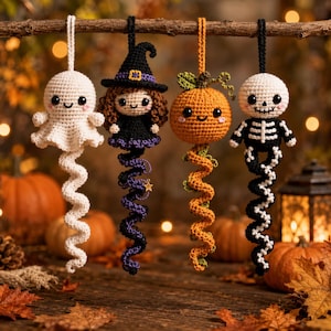 May include: Four crocheted hanging ornaments featuring a white ghost, a witch with a black hat and purple dress, an orange pumpkin, and a black and white skeleton. Each figure has a smiling face and a long, spiraling tail hanging from a branch.
