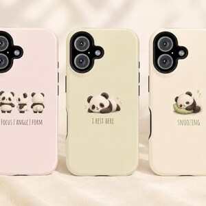 May include: Three smartphone cases in light pink, pale yellow, and cream. Each features a panda illustration and text: the pink case says FOCUS | ANGLE | FORM, the yellow case says I REST HERE, and the cream case says SNOOZING. All have black camera cutouts.