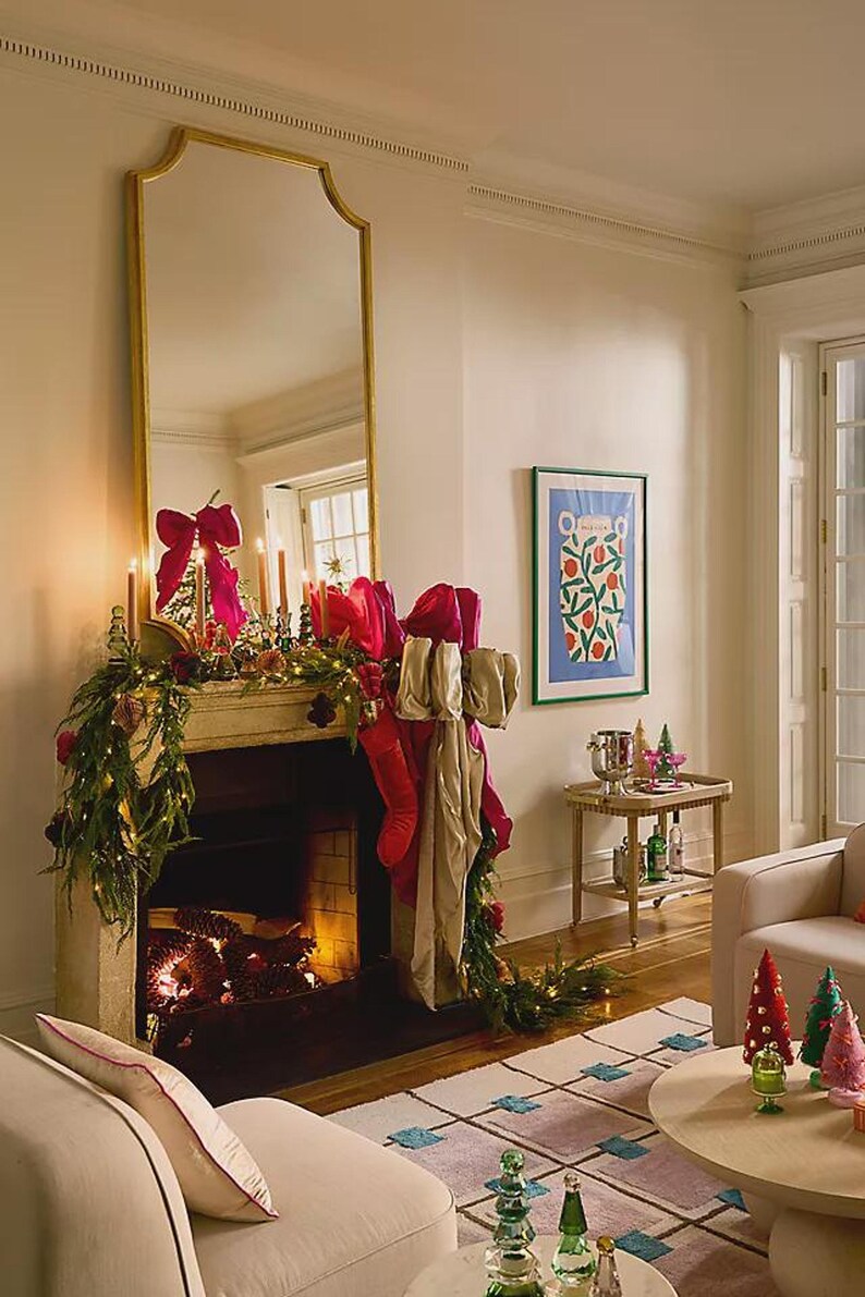 A living room interior featuring the patterned wool rug on the wooden floor in front of a fireplace decorated with holiday garlands and stockings.