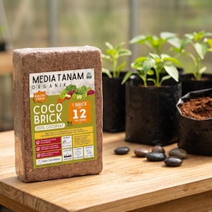 Może przedstawiać: Prostokątny blok sprasowanego organicznego podłoża kokosowego owinięty przezroczystą folią. Etykieta zawiera tekst Media Tanam Organik Coco Brick, 100% Cocopeat oraz 1 Brick Jadi 12 Polybag, wraz z różnymi ikonami i szczegółami tekstowymi.