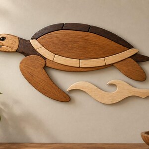 May include: A wall-mounted wooden sea turtle sculpture composed of multiple wood tones including light, medium, and dark brown segments. The turtle is depicted in a swimming motion with a stylized light-colored wooden wave shape positioned below.