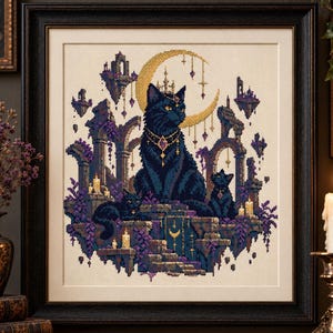 May include: A framed cross-stitch embroidery featuring three black cats sitting among stone ruins and purple foliage. A large golden crescent moon hangs in the background, accented by hanging charms, candles, and floating stone structures.