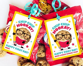 May include: Two printable gift tags featuring a cartoon chip cookie with glasses and a book. The tags are yellow with red, blue, and white accents. The text on the tags reads "Chip Chip Hooray! Happy First Day!"