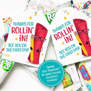 May include: White gift tags with the text "Thanks for Rollin' In! See you on the first day!" feature a red scroll wearing glasses and a yellow pencil. The tags are tied with white ribbon and are paired with candy.
