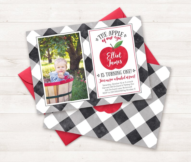 May include: A black and white checked invitation with a red apple graphic. The text reads "The apple of our eye Elliot James is turning one! Join us for a bushel of fun! Saturday, October 12 at 3 o'clock Harvest Hill Orchard by Petting Zoo 345 Orchard Lane, Richmond RSVP to 234.555.6789 by October 8"