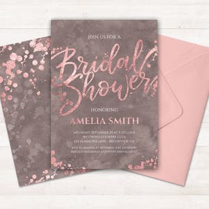May include: A blush pink and gray bridal shower invitation with rose gold foil lettering. The invitation reads "Join us for a Bridal Shower Honoring Amelia Smith" and includes the date, time, location, and RSVP information.