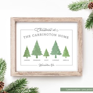 May include: A framed print with a light wood frame. The print features green watercolor Christmas trees and the text "Christmas at THE CARRINGTON HOME" with family names below. The town of Warrenton, VA is also printed on the bottom.