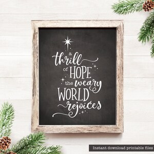 Puede incluir: Una pizarra negra con un marco de madera blanco, con una cita navideña: "A thrill of hope the weary world rejoices".