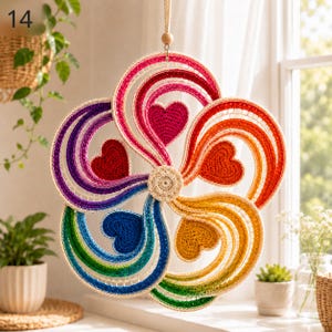 May include: A circular crochet wall hanging featuring a vibrant rainbow color scheme arranged in five swirling arms. Each arm contains a solid crocheted heart in a matching color, radiating from a central beige circular crochet motif.