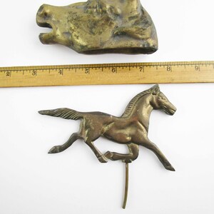 May include: Two antique brass figurines: a horse running and a horse head. The horse head is about 6 inches long and the horse is about 6 inches tall.