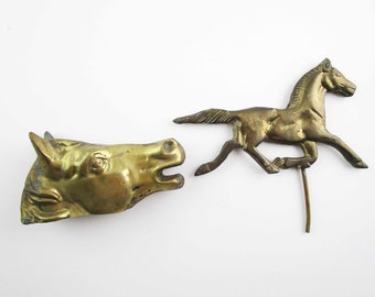 May include: Two brass horse figurines. One is a full-bodied horse running, the other is a horse head.