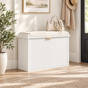 May include: A white storage bench with a fluted front panel, a gold-toned handle, and a beige upholstered seat cushion. The rectangular bench features a clean, solid frame and a smooth top surface, providing a functional seating and storage solution.
