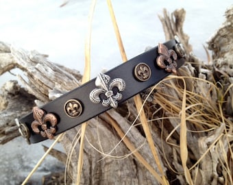 Puede incluir: Collar de cuero negro con detalles de lis en plata y cobre.