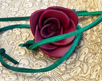 Rosa in pelle rossa con stelo in pelle e dettaglio di spine