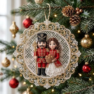 Könnte beinhalten: Ein runder Weihnachtsschmuck mit einem Nussknacker-Soldaten in roter Uniform und einer weiblichen Figur in rotem Mantel mit einem Korb voller Walnüsse, umrahmt von filigraner weiß-goldener Spitzenstickerei mit einer goldenen Kordel.
