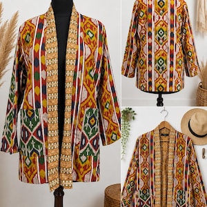 May include: A long-sleeved open-front jacket featuring a vibrant ikat pattern in shades of mustard yellow, deep red, forest green, and navy blue. The garment includes a contrasting mustard yellow patterned collar and two large front patch pockets.