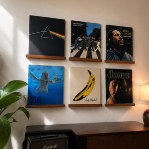 Peut inclure: Six pochettes de disques vinyles carrées exposées sur deux étagères murales en bois. Les albums incluent The Dark Side of the Moon de Pink Floyd, Abbey Road des Beatles, What's Going On de Marvin Gaye, Nevermind de Nirvana, The Velvet Underground & Nico et The Doors.