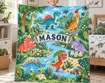 May include: A soft, rectangular fleece blanket featuring a vibrant, colorful jungle scene with various cartoon dinosaurs, lush green foliage, a winding blue river, and the name MASON printed in large, bold, dark blue letters across a stone archway.