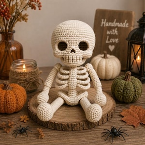 May include: A cream-colored crocheted skeleton figure with a round head, hollow eye sockets, and a rib cage structure. The figure is seated on a circular wooden slice, featuring a textured yarn surface and detailed stitching throughout the body.