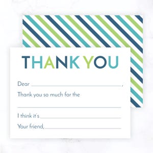 May include: A white thank you card with a blue, green, and yellow striped pattern on the back. The front of the card has the words "THANK YOU" in large, colorful letters. The card has blank lines for writing a message.