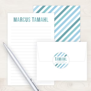 a pen, a piece of paper with a name written on it, and an envelope with a circular label.
