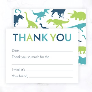 May include: A white thank you card with a blue and green dinosaur pattern on the back. The front of the card has the words "THANK YOU" in blue, green, and light blue. The card has lines for writing a message.