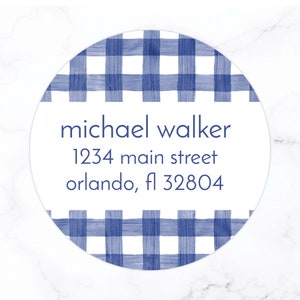 May include: A round white sticker with a blue and white gingham pattern. The sticker has the text "michael walker", "1234 main street", and "orlando, fl 32804" printed in blue.