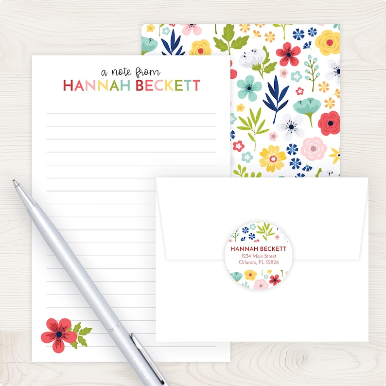 A note from Hannah Beckett, a pen, an envelope, and a floral patterned envelope liner are arranged on a wooden surface.