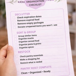 May include: A white paper pantry organization checklist with purple text and lavender illustrations. The document includes sections titled Declutter, Sort & Group, Restock, and Pantry Reset Complete, with checkboxes next to each task list item.
