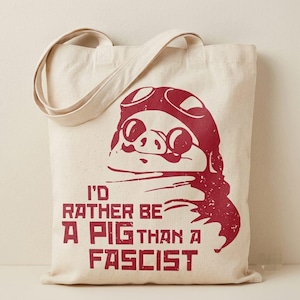 Può includere: Una borsa tote in tela color naturale con una stampa grafica rosso scuro di un maiale che indossa occhiali da aviatore. Sotto l'illustrazione, il testo recita: I'D RATHER BE A PIG THAN A FASCIST. La borsa ha due tracolle.