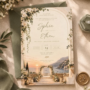 May include: A rectangular wedding invitation card featuring an arched frame with floral accents, text reading Sophia and Ethan, and a sunset coastal scene of Positano, Italy. The card includes event details for Saturday, June 14, 2025, at Villa Aurora.