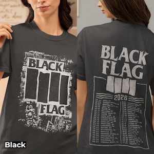 May include: A charcoal gray t-shirt featuring a distressed white Black Flag logo graphic on the front. The back displays the Black Flag logo above the text 2026 and a detailed list of tour dates and locations printed in a white, weathered font.