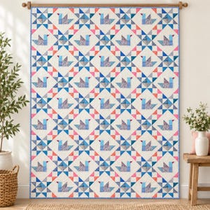 May include: A rectangular quilt featuring a repeating pattern of blue bird shapes and geometric star motifs. The design incorporates a cream-colored background with accents of pink, light blue, and dark blue fabric squares arranged in a grid.