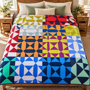 Puede incluir: Una colcha multicolor que presenta un diseño de patchwork geométrico con varios bloques cuadrados. Cada bloque muestra un patrón único de triángulos y cuadrados en tonos vibrantes de rojo, naranja, amarillo, verde, azul, morado y blanco.