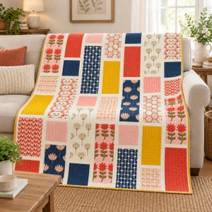 Könnte beinhalten: Ein rechteckiger Steppdecke mit einem Patchwork-Design aus vertikalen Spalten mit abwechselnden Mustern, darunter rote Blumen, marineblaue geometrische Formen, gelbe Blöcke, rosa Sechsecke und wiederkehrende Katzengesichter auf cremefarbenem Grund.