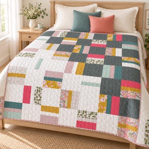 May include: A quilted bedspread featuring a patchwork design of rectangular blocks in white, charcoal gray, mustard yellow, hot pink, teal, and floral patterns. The quilt has a diamond-stitched texture and covers a bed with white and colored pillows.