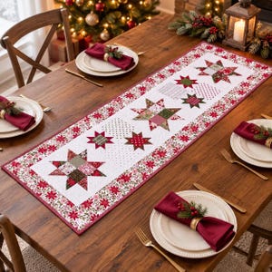 Puede incluir: Un camino de mesa acolchado rectangular con fondo blanco y un patrón repetitivo de estrellas de patchwork rojas y verdes con un borde floral. El camino está colocado sobre una mesa de madera con platos blancos y servilletas rojas.