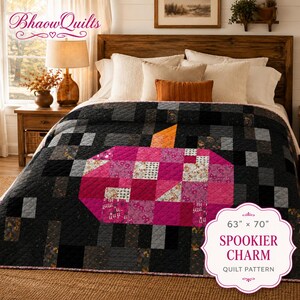 Può includere: Una trapunta con un grande motivo centrale a zucca in tonalità rosa e motivi floreali, su uno sfondo patchwork grigio scuro e nero. La trapunta misura 63 pollici per 70 pollici ed è etichettata come Spookier Charm quilt pattern.
