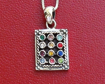 May include: A silver chain necklace with a square pendant featuring a colorful mosaic of small gemstones.