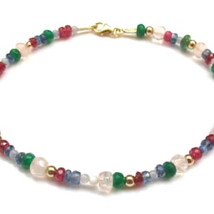 May include: A gold chain bracelet featuring a range of colourful gemstones, including pink, red, green, and blue.