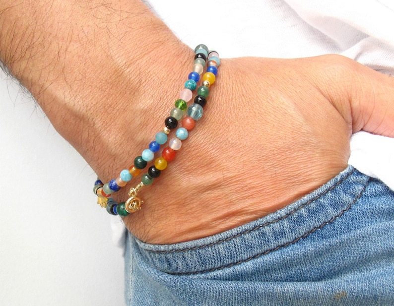 Pode incluir: Um bracelete de contas multicoloridas com um fecho de ouro. O bracelete &eacute; feito com uma variedade de pedras, incluindo azul, verde, vermelho e laranja.