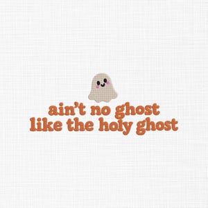 May include: An embroidered design featuring a small, beige, smiling ghost with pink cheeks positioned above the orange text that reads, "ain't no ghost like the holy ghost," all set against a white fabric background with a visible weave.