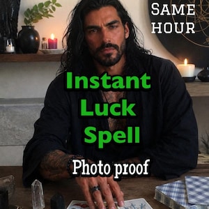 Könnte beinhalten: Eine Person mit langem dunklem Haar in einem schwarzen Hemd sitzt an einem Holztisch mit drei Tarotkarten, darunter die Zwei der Kelche und die Drei der Schwerter. Der Text lautet SAME HOUR, Instant Luck Spell und Photo proof.