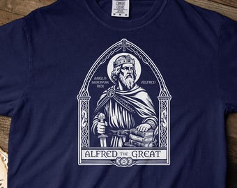May include: A navy blue short-sleeve t-shirt featuring a white graphic print of a king wearing a crown and holding a sword and books. The design is framed by an archway with the text "ANGLO SAXONUM REX ALFRED" and "ALFRED THE GREAT".