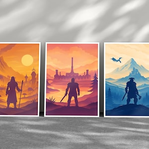 Peut inclure: Trois impressions d'art rectangulaires représentant des paysages fantastiques. L'image de gauche montre une silhouette avec un bâton près d'un volcan dans des tons orange. Celle du centre montre une silhouette avec une épée devant un château dans des tons roses. Celle de droite montre une silhouette avec une hache et un dragon près de montagnes bleues.