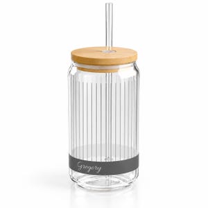 May include: A clear glass tumbler with vertical ribbed texture, a light wood lid, and a straight glass straw. The lower section features a solid dark gray band with the name Gregory written in a white cursive script font across the center.