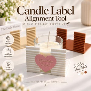 Könnte beinhalten: Ein Set aus weißen, beigen und braunen Kerzenetiketten-Ausrichtungshilfen mit gerippten Oberflächen. Das weiße Werkzeug hält eine Glaskerze mit einem rosa herzförmigen Etikett mit der Aufschrift Sweet day for you. Text enthält Candle Label Alignment Tool.