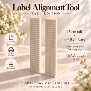 May include: A cream-coloured Label Alignment Tool Tall Edition with two vertical ribbed columns on an 8 by 8 cm base. The text reads Label Alignment Tool Tall Edition, 15 cm tall, 8 by 8 cm base, Print your own labelling tool, Make a wish by Nuii, Digital Download, 1 STL File, No physical item included.
