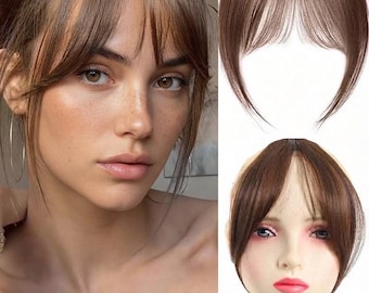 Peut inclure: Une frange à clipser de couleur brun moyen. Le postiche présente des mèches effilées et superposées qui encadrent le visage, conçues pour se fondre avec les cheveux naturels. Le produit est présenté seul et sur une tête de mannequin.